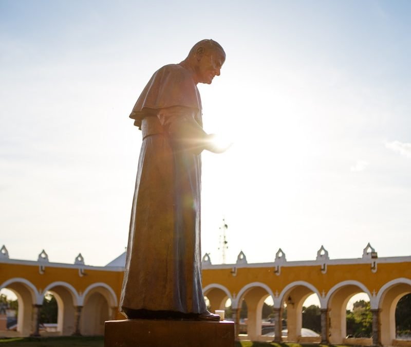 A statue of a man standing in front of a building