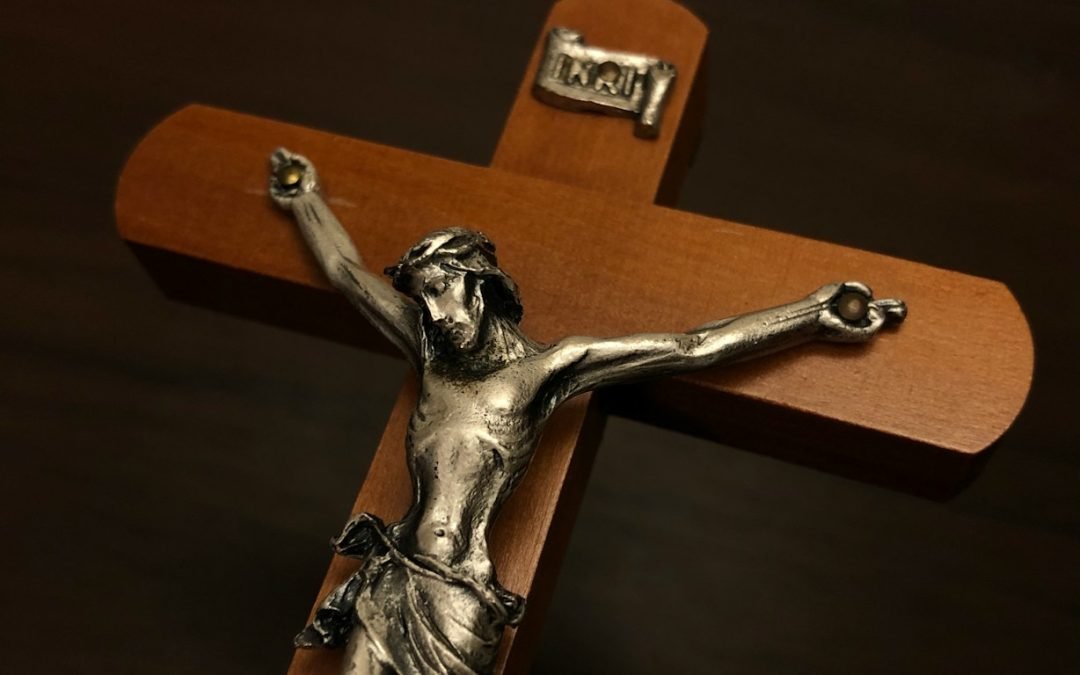 a silver crucifix on a wooden cross