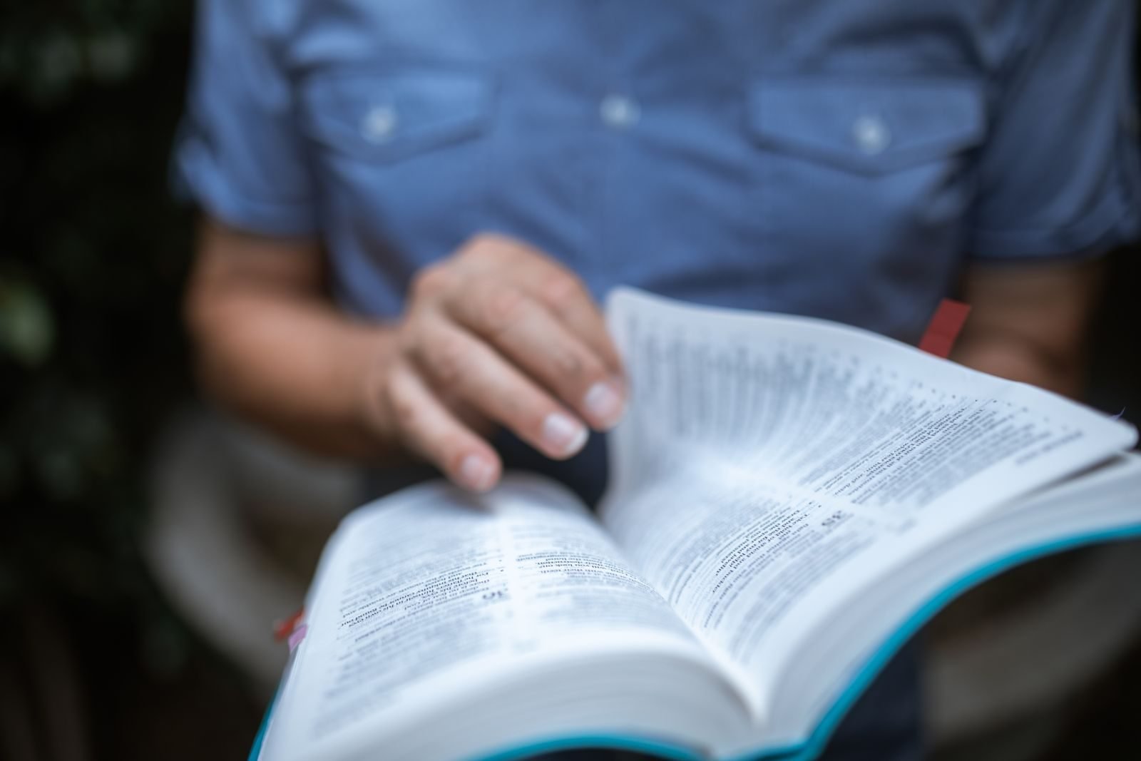 Close-up of an individual reading a Bible, emphasizing devotion and focus.
